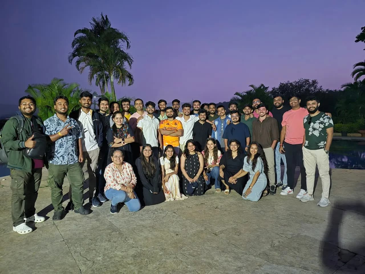 Nirmitee teammates together outdoors at dusk during a team offsite